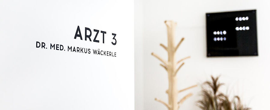 Tür vom Arztzimmer und stylischer Wanduhr